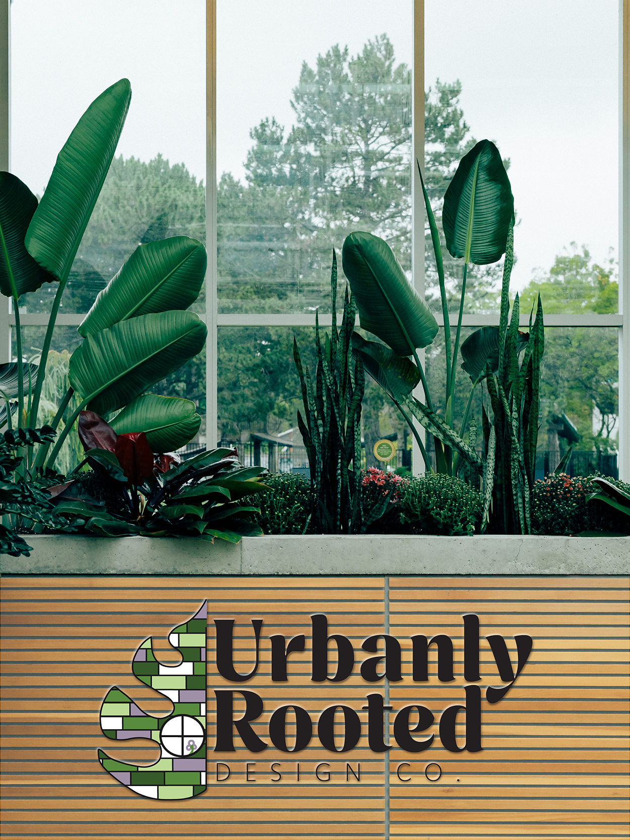 Mockup of the Urbanly Rooted Logo placed on a slated wooden planter box with large indoor plants in front of the large windows of a city highrise.